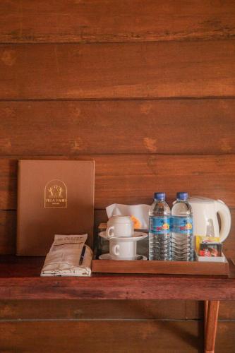 a shelf with a box and cups and water bottles at Villa Tahid in Gili Air