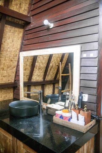 a bathroom with a sink and a mirror at Villa Tahid in Gili Air
