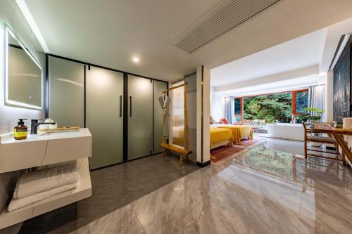 a bedroom with a yellow bed and a large window at Huagu Jianzhu Guesthouse (Zhangjiajie National Forest Park Branch) in Jiawan