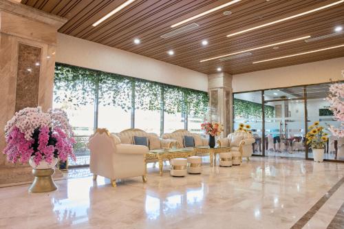 un vestíbulo con una sala de espera con sillas y flores en Khách Sạn Rex An Nhơn, en Hòa Nghi