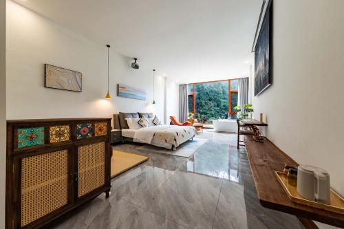 a living room with a bed and a couch at Huagu Jianzhu Guesthouse (Zhangjiajie National Forest Park Branch) in Jiawan