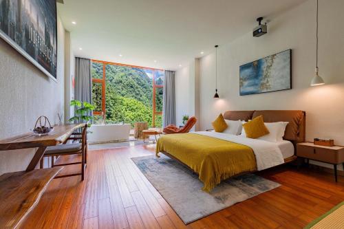 a bedroom with a bed and a table and a desk at Huagu Jianzhu Guesthouse (Zhangjiajie National Forest Park Branch) in Jiawan