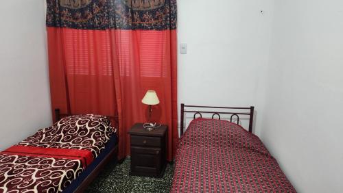a bedroom with two beds and a lamp on a night stand at Casa Famatina in Chilecito