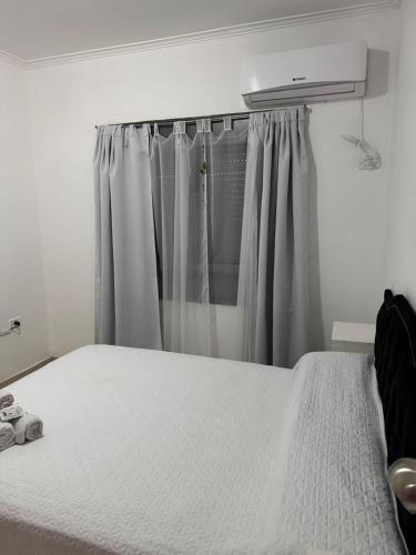 a bedroom with a white bed and a window at DPTO BOULEVARD GALVEZ CON COCHERA, Santa Fe in Santa Fe