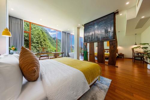 a bedroom with a large tv and a large bed at Huagu Jianzhu Guesthouse (Zhangjiajie National Forest Park Branch) in Jiawan