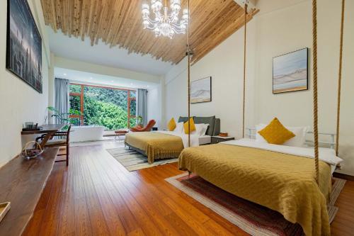 a bedroom with two beds and a chandelier at Huagu Jianzhu Guesthouse (Zhangjiajie National Forest Park Branch) in Jiawan