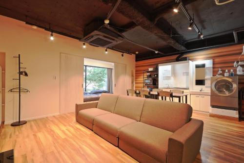 a living room with a couch and a kitchen at Steps from Shibuya Crossing B in Tokyo