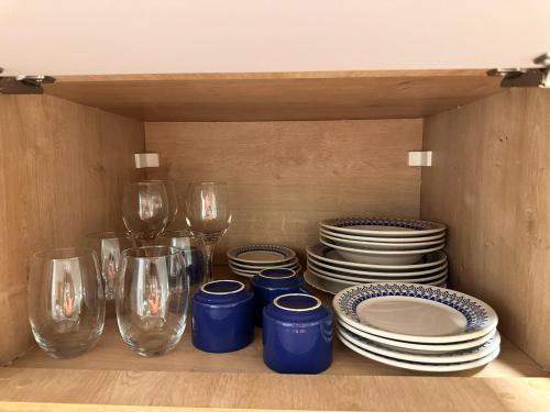 a shelf with plates and wine glasses and plates at Flat localizado a 200m Shopping Recife, bem Perto da Praia de Boa Viagem e com Wi-Fi 400Mbps in Recife
