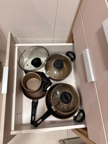 a cabinet with four pots and pans in it at Flat localizado a 200m Shopping Recife, bem Perto da Praia de Boa Viagem e com Wi-Fi 400Mbps in Recife
