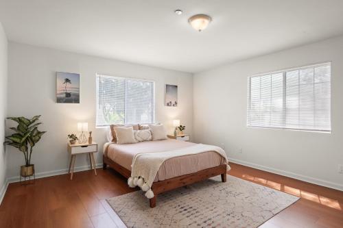 a white bedroom with a bed and two windows at Dazzling 4BR Near Amazon Studios Venice Beach in Los Angeles