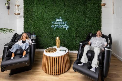 a man and a woman sitting in chairs around a table at Barossa Palms Motel in Nuriootpa