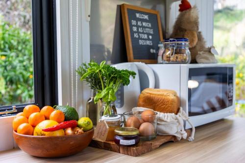 a bowl of fruit on a counter next to a microwave at Creekside at Kūaotunu in Matarangi