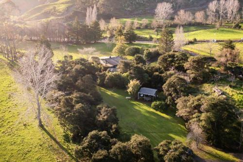 an aerial view of a house in a field with trees at Creekside at Kūaotunu in Matarangi