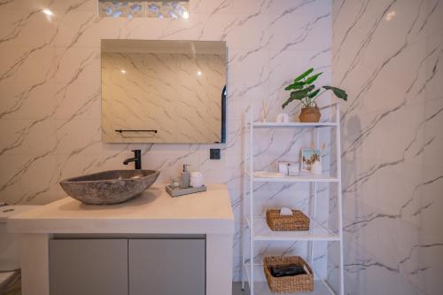 un baño con lavabo y espejo en Villa Intisar - luxury oasis in Canggu, en Canggu