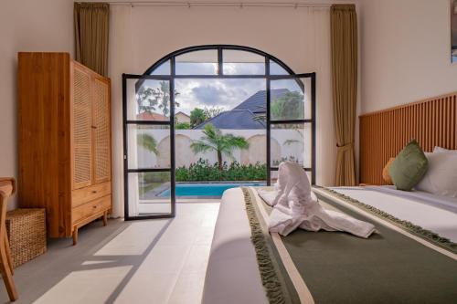Un dormitorio con una cama y una ventana grande. en Villa Intisar - luxury oasis in Canggu, en Canggu