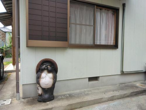 a statue of a gorilla on the side of a house at Nagata House in Ise