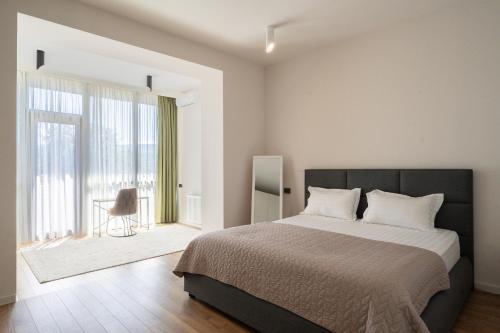 a bedroom with a large bed and a large window at Niabi Villa with pool in Tbilisi City