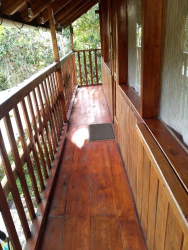 a porch of a cabin with a wooden floor at Cabaña Familiar Mindo in Mindo
