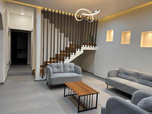 a lobby with couches and a table and a staircase at Casa Na-há in Tuxtla Gutiérrez