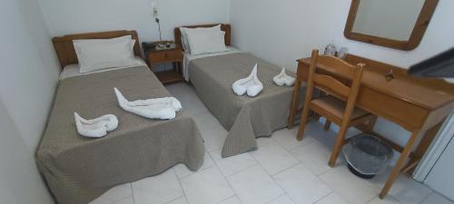 a room with two beds and a desk and a piano at ΣΕΡΙΦΟΣ ΜΠΙΤς in Livadion
