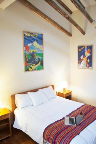 a bedroom with a white bed and two night stands at Maison Fortaleza in Cusco