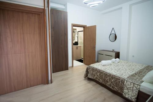 a bedroom with a bed and a sliding door at Gratia Apartments in Kumanovo