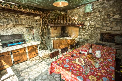 a kitchen with a table in a stone room at Rozina Vacation House in Pliskovica