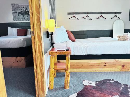 a bedroom with two beds and a table with a stool at Elk Antler Inn in Thermopolis