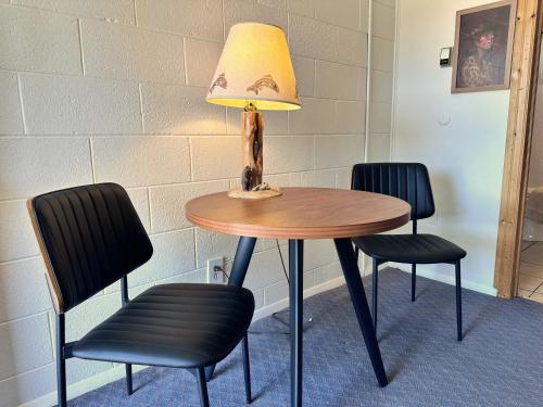 a table with two chairs and a lamp on it at Elk Antler Inn in Thermopolis