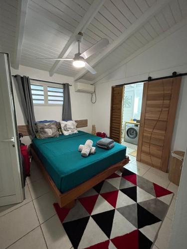 a bedroom with a bed and a checkered floor at la Canne a sucre in Pointe-Noire