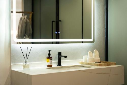 a bathroom with a sink and a mirror at Huagu Jianzhu Guesthouse (Zhangjiajie National Forest Park Branch) in Jiawan