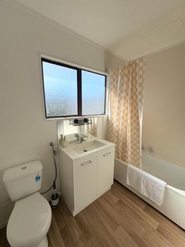オークランドにあるCozy 2BR, Sleep 4, Free Parkingのトイレ、洗面台、窓のあるバスルーム
