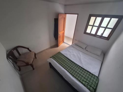 a small bedroom with a bed and a window at Penthouse - Altos de Iguaque in Gámbita