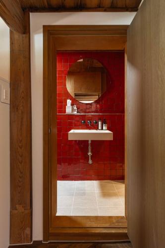 a red bathroom with a sink and a red wall at Luxury Hanok Sangseon Heritage Hanok-W in Cheongju