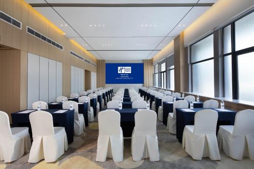 a conference room with chairs and tables and a screen at Holiday Inn Express Chengdu Wuhou New City by IHG in Chengdu