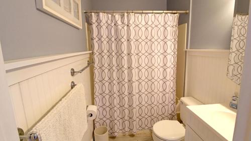 Un baño con cortina de ducha y un inodoro. en Capers Unit 803, en Cape May