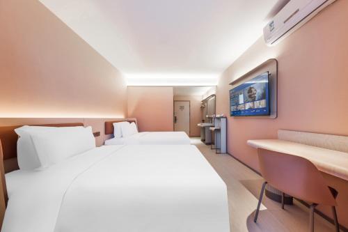 a hotel room with two beds and a desk at Hanting Hotel Beijing Guang'anmen in Beijing