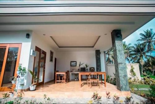a house with a table and chairs on a patio at Villa Popolan and Guest House in Ubud