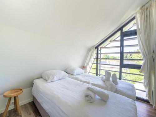 two beds in a room with a large window at Holiday home Waterland for six Person in Egmond aan den Hoef
