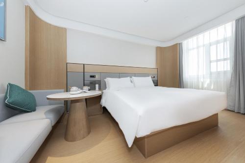 a hotel room with a large bed and a couch at JI Hotel Beijing Fangshan Commercial Street in Beijing