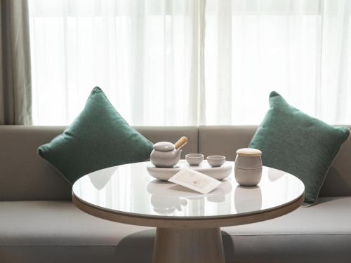a coffee table in a living room with green pillows at JI Hotel Beijing Fangshan Commercial Street in Beijing