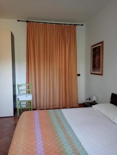 a bedroom with a bed and a window with a chair at Contrada Macchia B&B in Tricase
