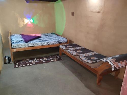a small room with two bunk beds and a table at Natural mudhouse in Kanthalloor