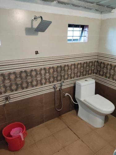 a bathroom with a toilet and a shower at Natural mudhouse in Kanthalloor