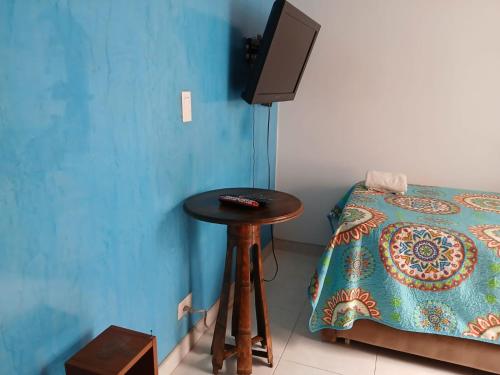 a room with a table and a bed and a television at Casa Ambrosía Eje Cafetero in Pereira