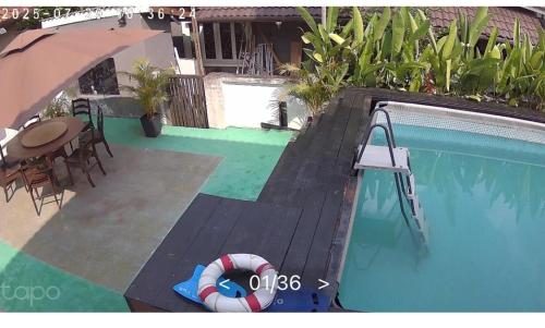 a swimming pool with a beach ball and an umbrella at MIA guests house in Nilai