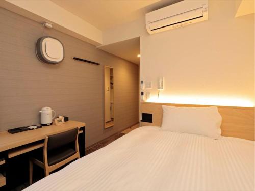a hotel room with a bed and a desk and a bed sidx sidx sidx sidx at A&Bee HOTEL in Oita