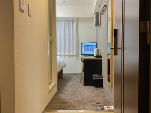 a hallway of a hotel room with a desk and a computer at A&Bee HOTEL in Oita