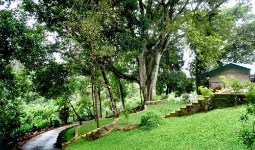 a garden with a small house and a path at Mirage Kandyan Heights in Kandy