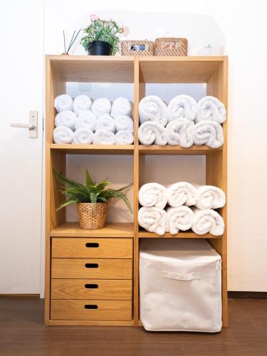 a wooden book shelf filled with towels at Setouchi Inn Minamoみなも in Takamatsu